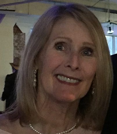 A woman with blonde hair and wearing earrings.