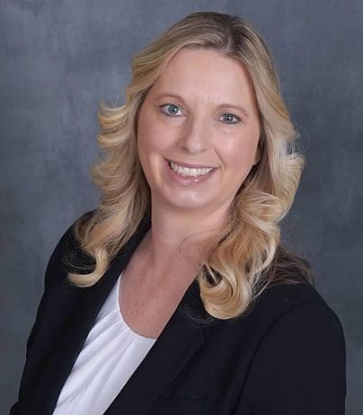 A woman with blonde hair and wearing a black jacket.