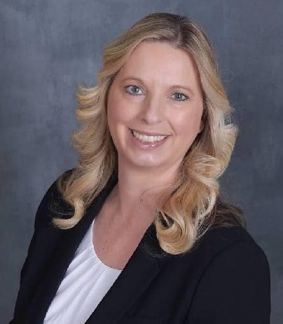 A woman with blonde hair and wearing a black jacket.