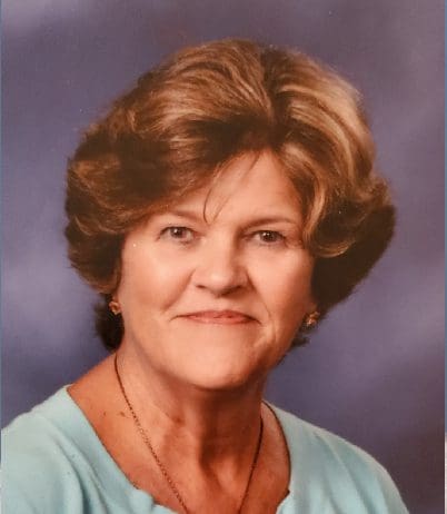 A woman with short hair and wearing a blue shirt.