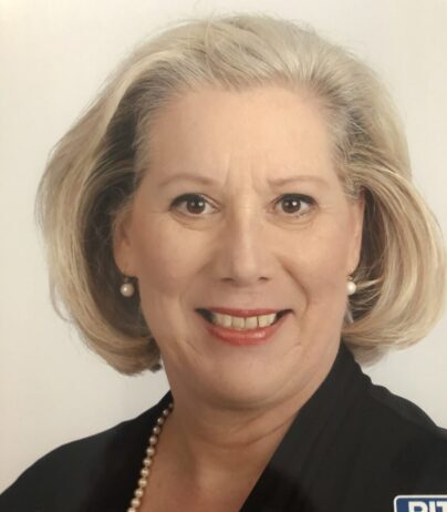 Portrait of a smiling middle-aged woman with short blonde hair.